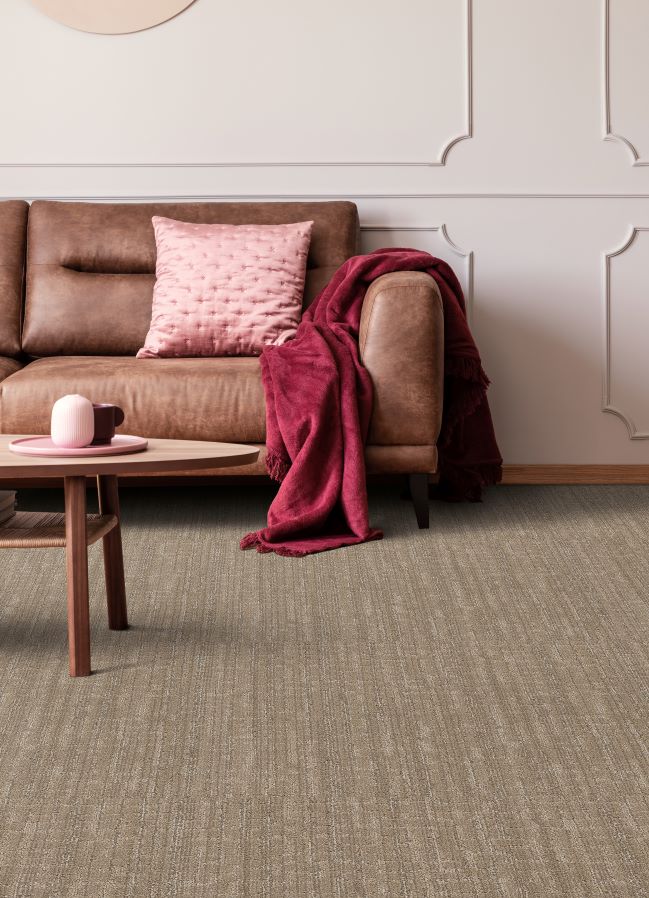 brown carpet in a modern living room with a leather couch and pink accents