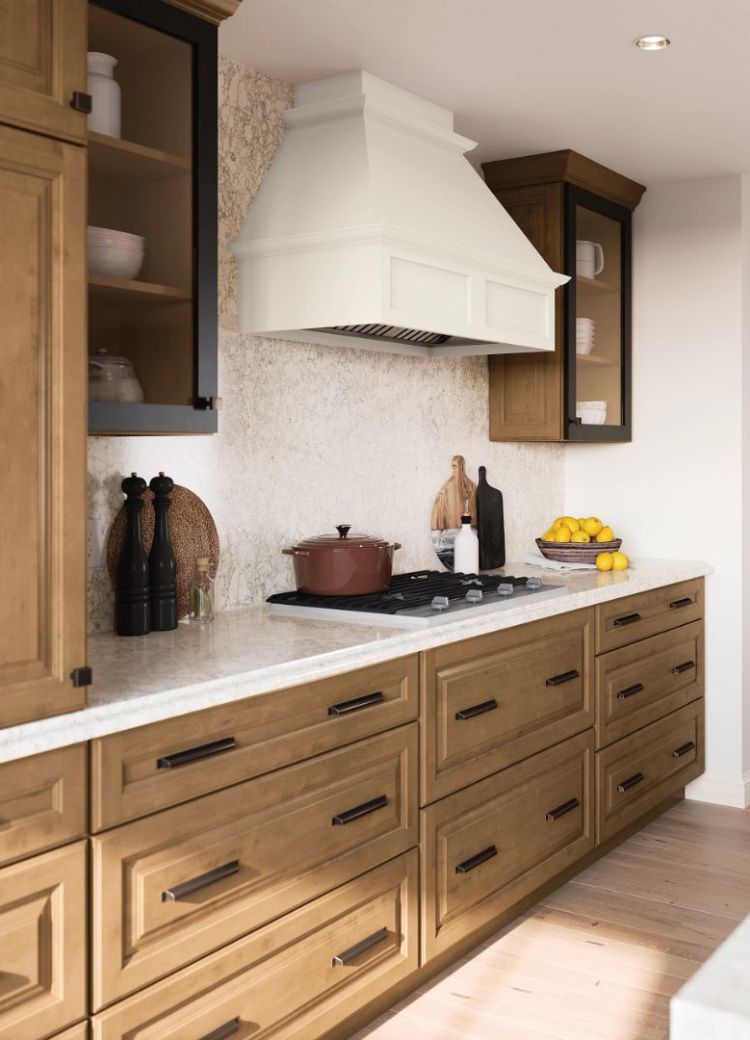 matte black cabinet hardware in a stylish kitchen with wood cabinets, tile backsplash, and range hood from Kiba Studios Houston