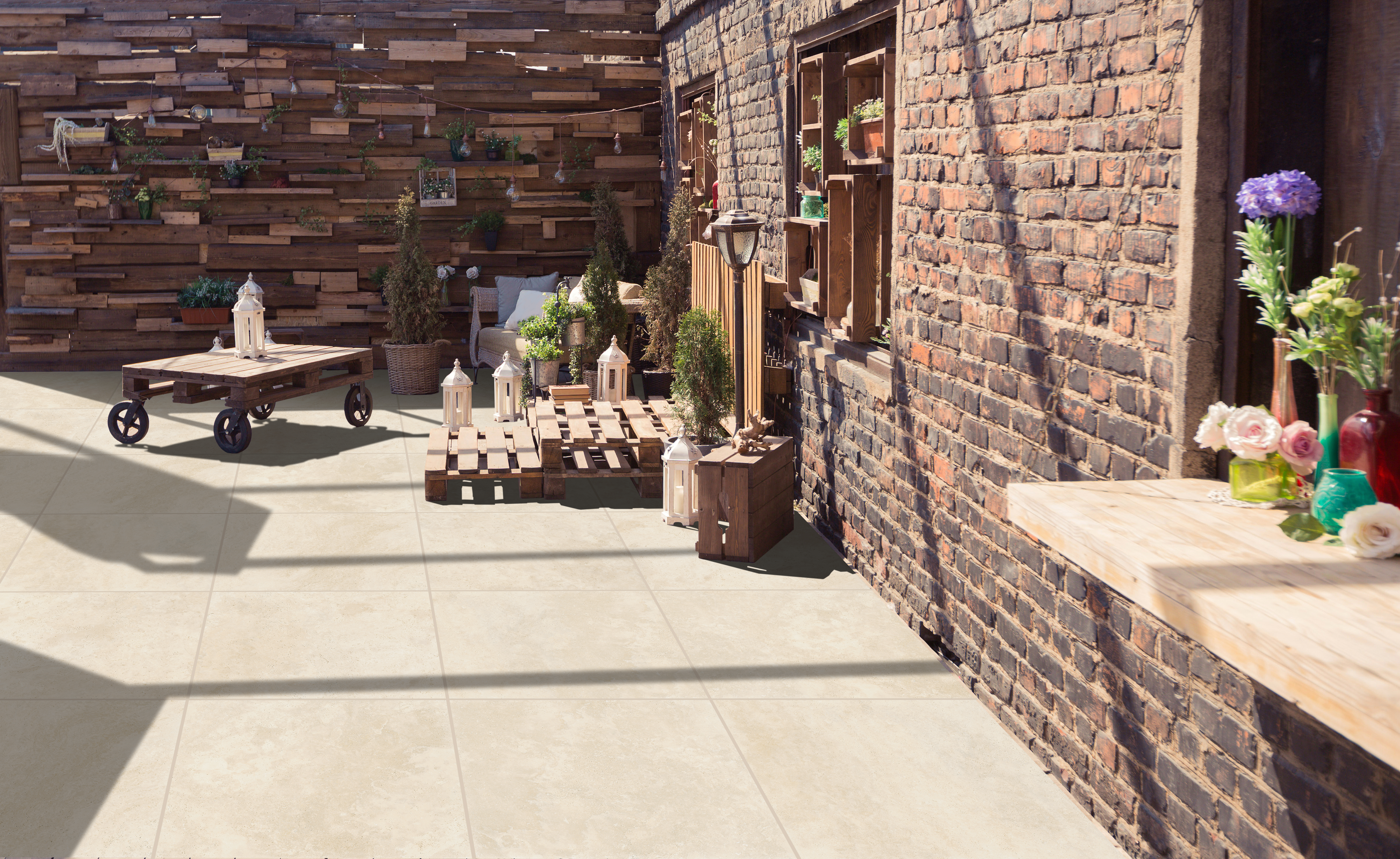 Outdoor patio area with stone tile, brick wall backdrop near building